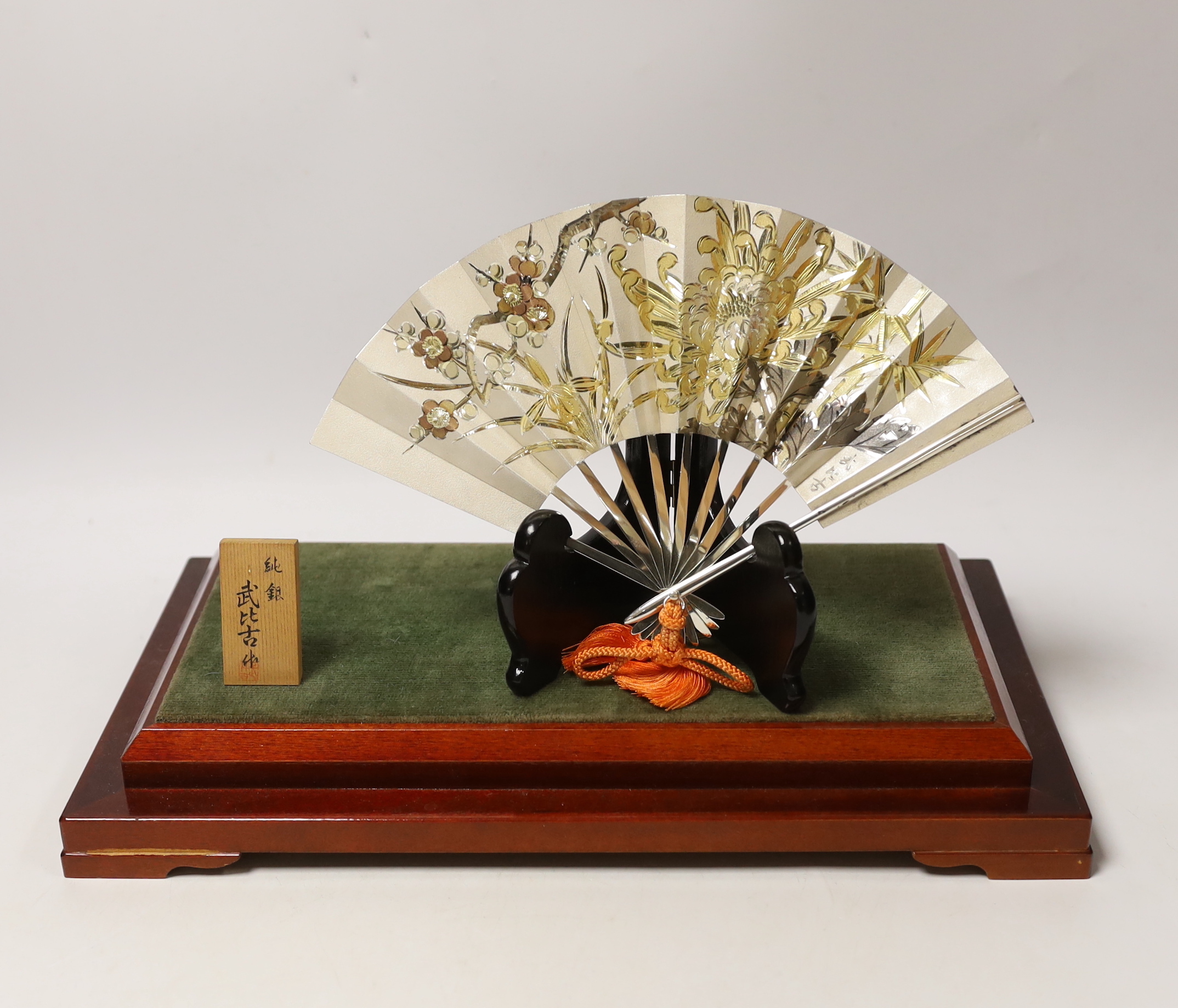 A Japanese white metal fan ornament on stand, signed, 24cm wide